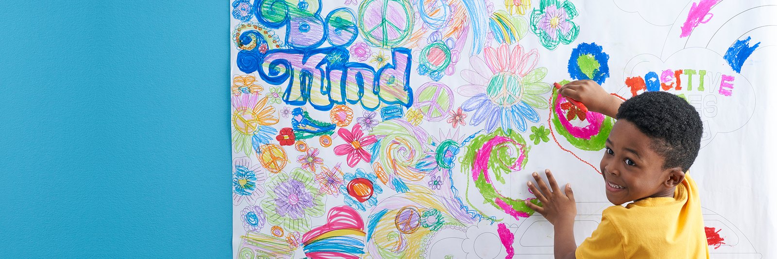 A child coloring a large Creatology wall poster